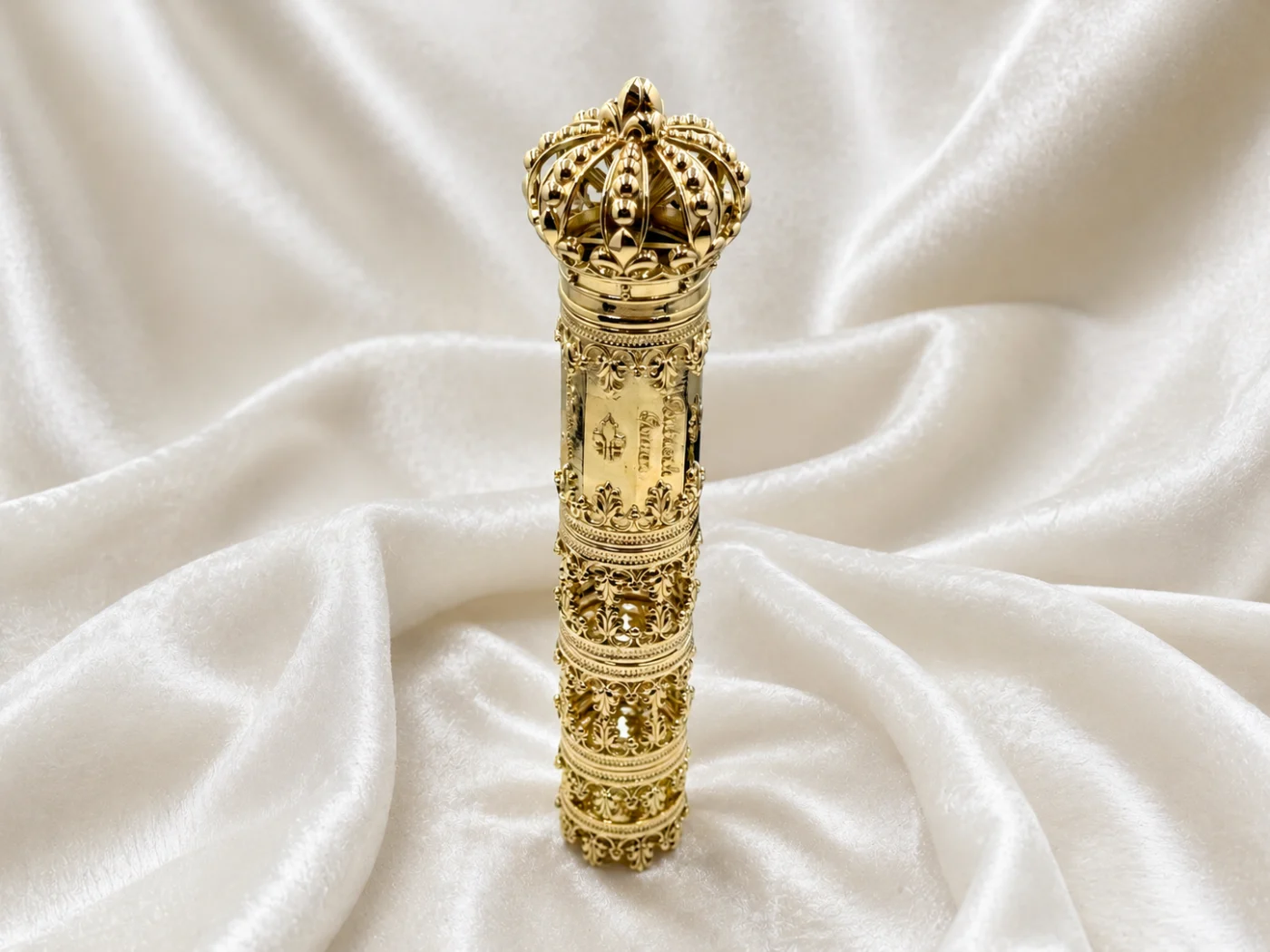 Außergewöhnliches, aufwendig ornamentiertes Goldobjekt mit kronenförmigem Abschluss auf heller Seide