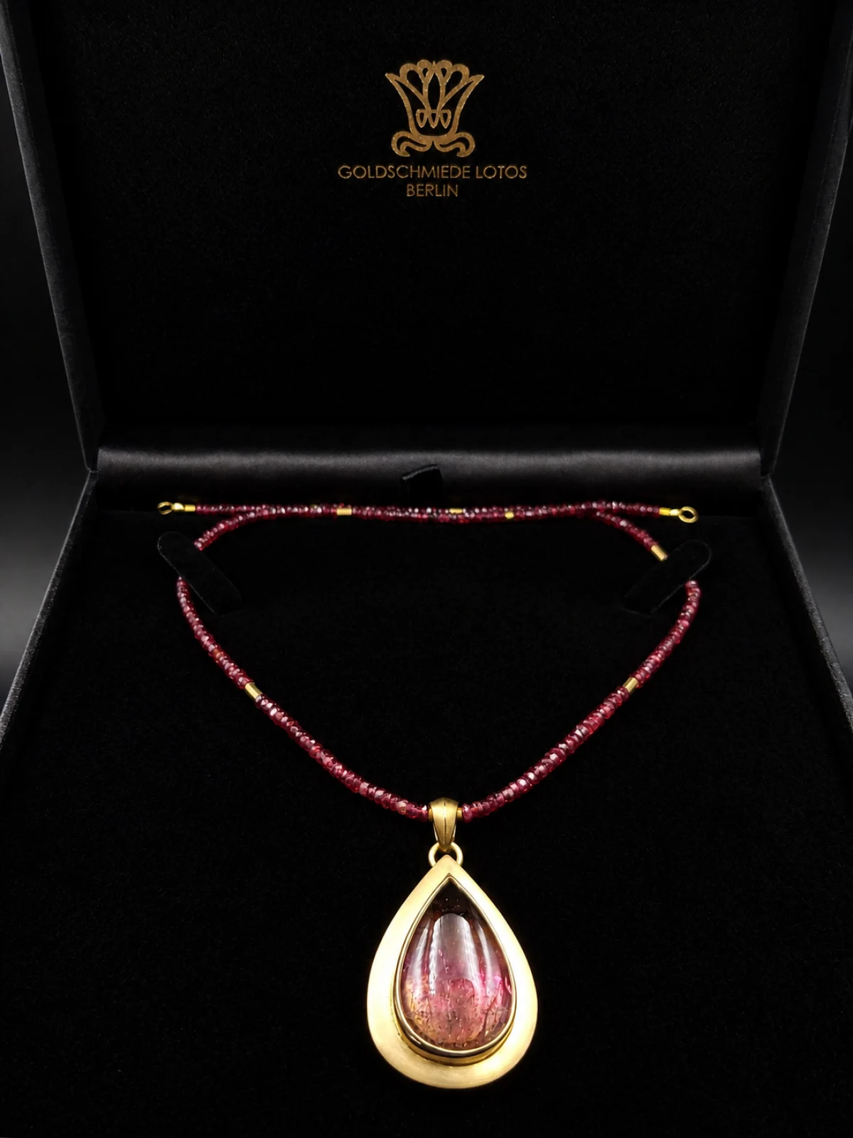 Handgefertigtes Collier mit rotem Turmalin-Anhänger in einer schwarzen Präsentationsschatulle der Goldschmiede Lotos