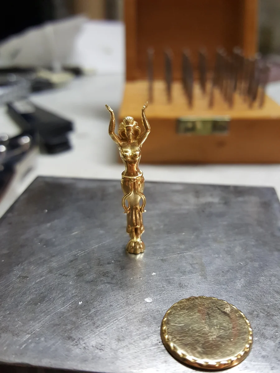 Von Hand ausgearbeitete goldene Figur während der Anfertigung