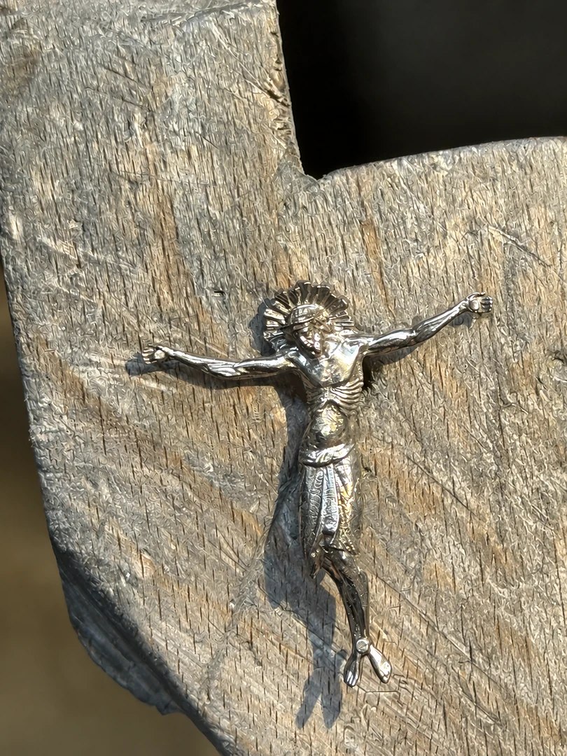Silberne Christusfigur bei der handwerklichen Bearbeitung an der Werkbank